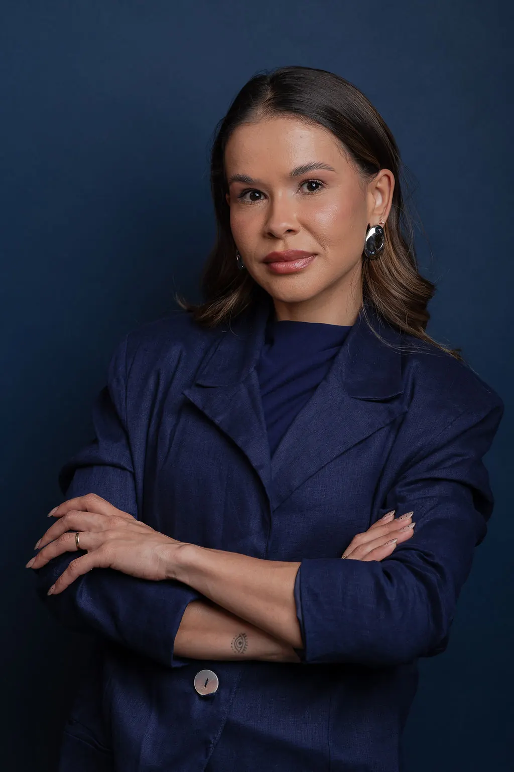 Retrato de Joyce Borges de braços cruzados, com blazer azul